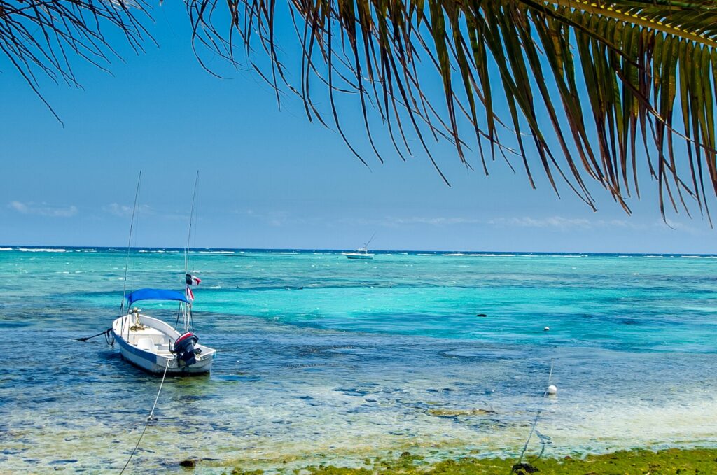 Small boat floating in clear Caribbean water near the Puerto Morelos beach.