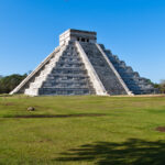 The iconic El Castillo pyramid at Chichén Itzá, a UNESCO World Heritage site, standing tall under a clear blue sky.