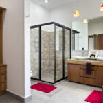 A modern bathroom with a large walk-in shower and double sinks.