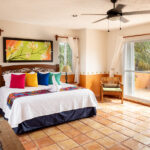 Bright bedroom with colorful pillows and Mexican decor.