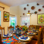 Dining table set for eight in a colorful Mexican-style room.