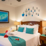 Bedroom with a queen bed, beach-themed art, and blue accents.