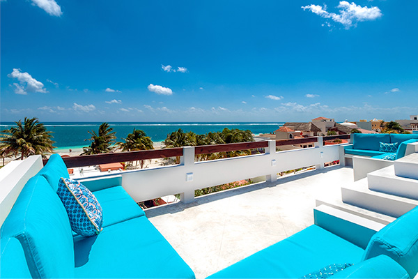 Rooftop lounge area with ocean views and blue seating at Casa Agua Azul.