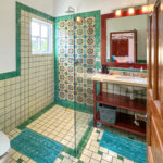 Casa Zarah full bathroom with colorful Talavera tile shower, large mirror, and walk-in layout.