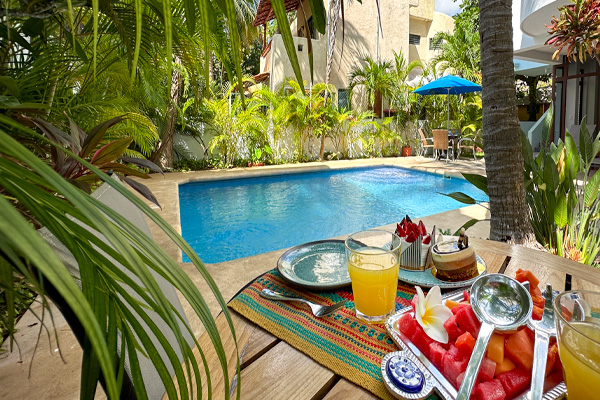 Breakfast by the pool at a vacation rental apartment in Puerto Morelos.