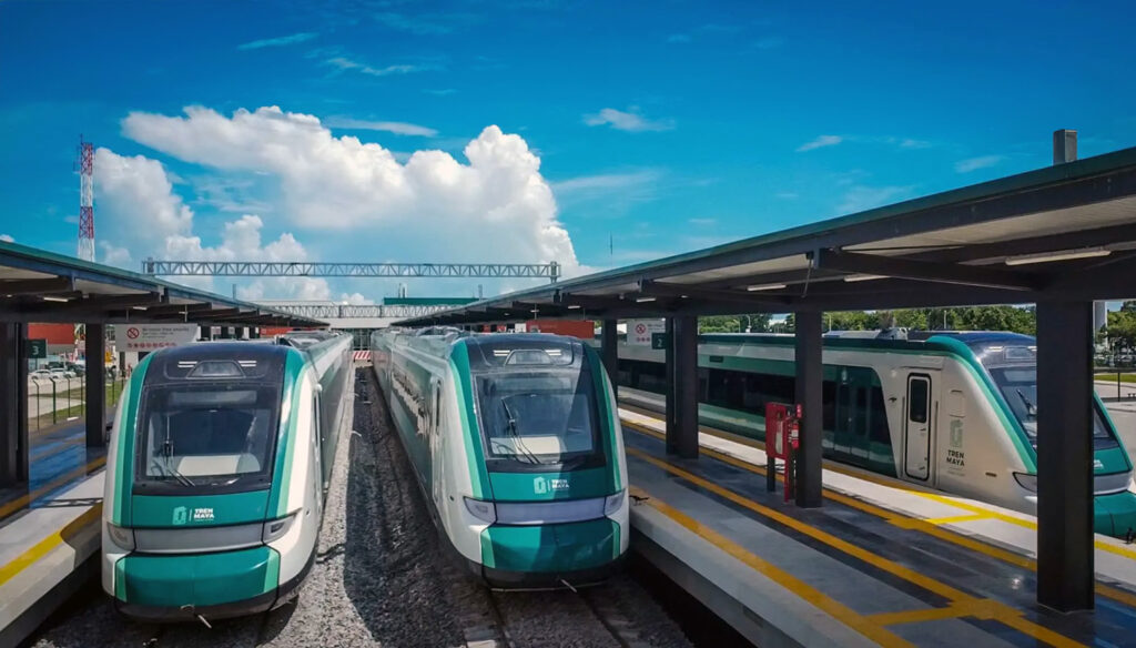 ren Maya trains at a modern station platform under a bright blue sky