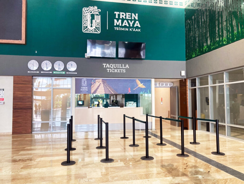 Tren Maya ticket counter inside a modern station with bilingual signage