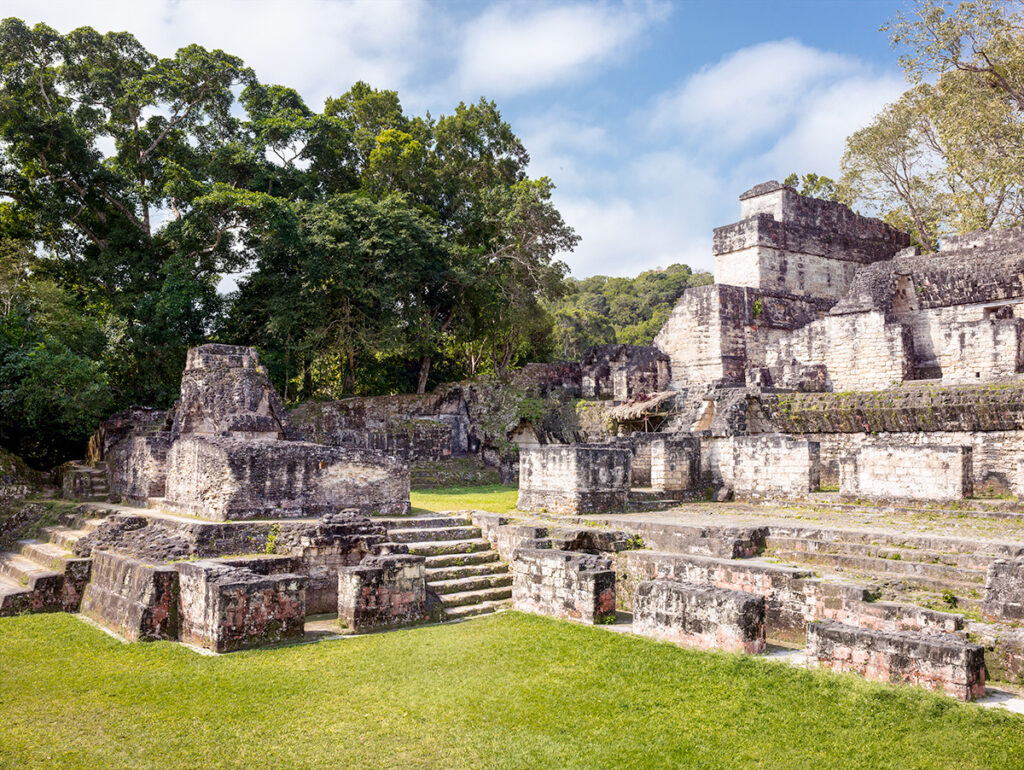 Ancient Maya ruins surrounded by jungle and blue sky