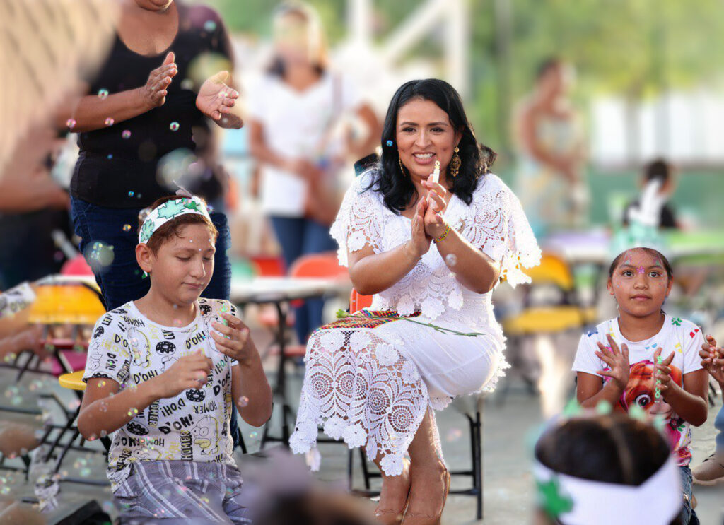 Mayor Blanca Merari Tziu claps alongside children during a public peace event in Puerto Morelos