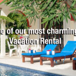 Poolside view of Casa Anita with blue lounge chairs and tropical greenery