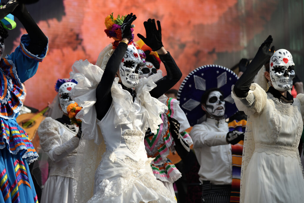 Performers dressed as La Catrina dancing during Día de Muertos celebrations in Puerto Morelos, Mexico.