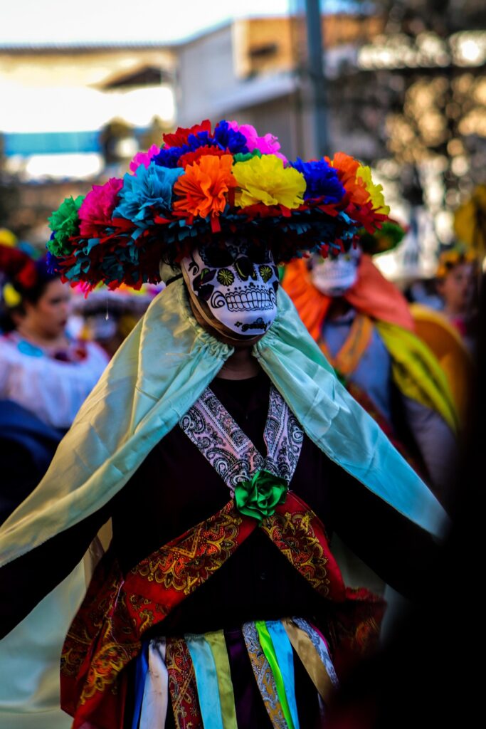 In Puerto Morelos, Mexico, the streets come alive each October with vibrant parades celebrating La Catrina. Performers dressed in vivid costumes and ornate skull masks dance and wave to the crowd, transforming satire into joy. What began as a social critique by José Guadalupe Posada now thrives as a beloved community celebration — honoring ancestors, culture, and the colorful spirit that defines Mexico’s Día de Muertos.