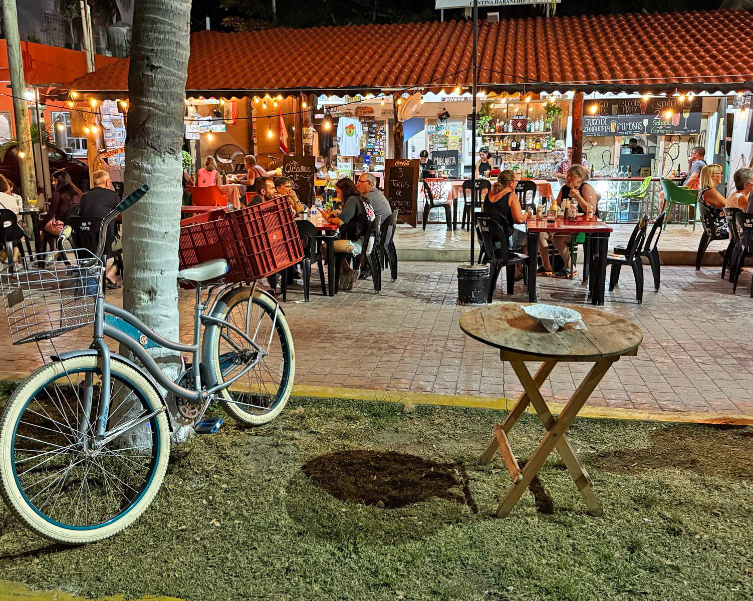 Residents and visitors dining outdoors during an evening in Puerto Morelos