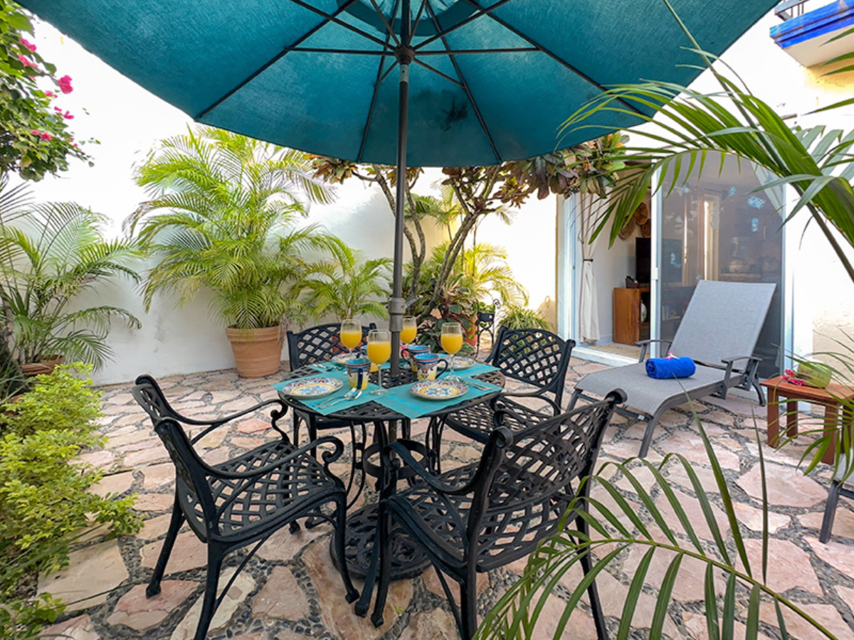 Private garden patio at Apartment A9 with outdoor dining and tropical plants in Puerto Morelos