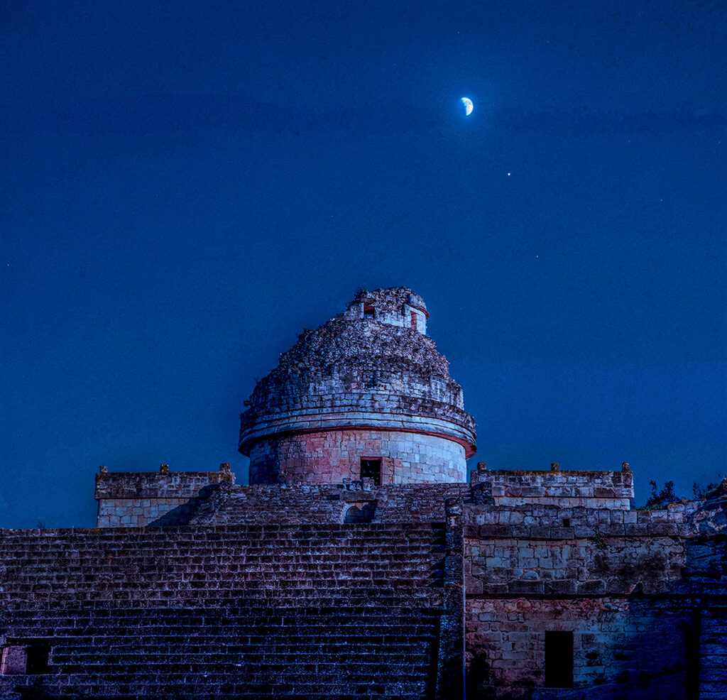 Ancient Maya observatory beneath a glowing moon in the deep blue evening sky.