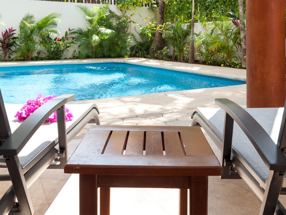 Poolside loungers beside a tropical swimming pool at Casa Sonoma Apt. 3 in Puerto Morelos