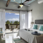 Bright bedroom at Casa Agua Azul with balcony doors and Caribbean view.