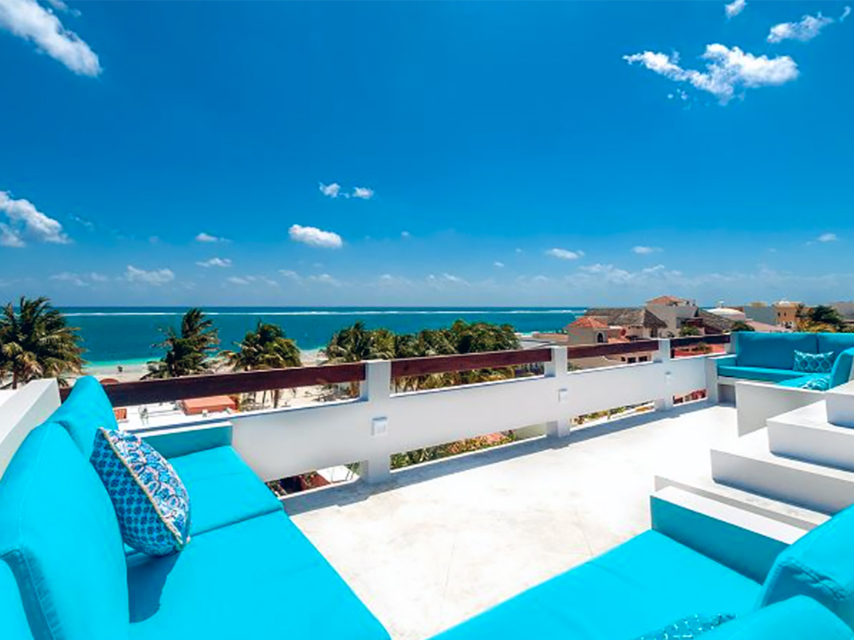 Rooftop terrace at Casa Agua Azul with turquoise seating and Caribbean views.