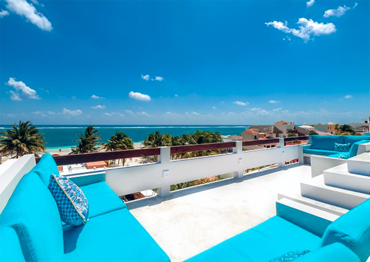 Rooftop terrace at Casa Agua Azul with turquoise seating and Caribbean views.