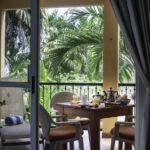 View from inside Apartment A#10 toward the private balcony and tropical garden.