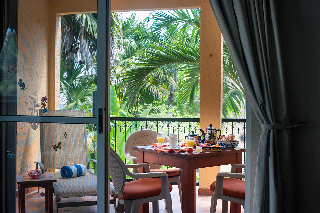 View from inside Apartment A#10 toward the private balcony and tropical garden.