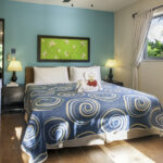King bed in Apartment A#10 with turquoise bedding and natural light.