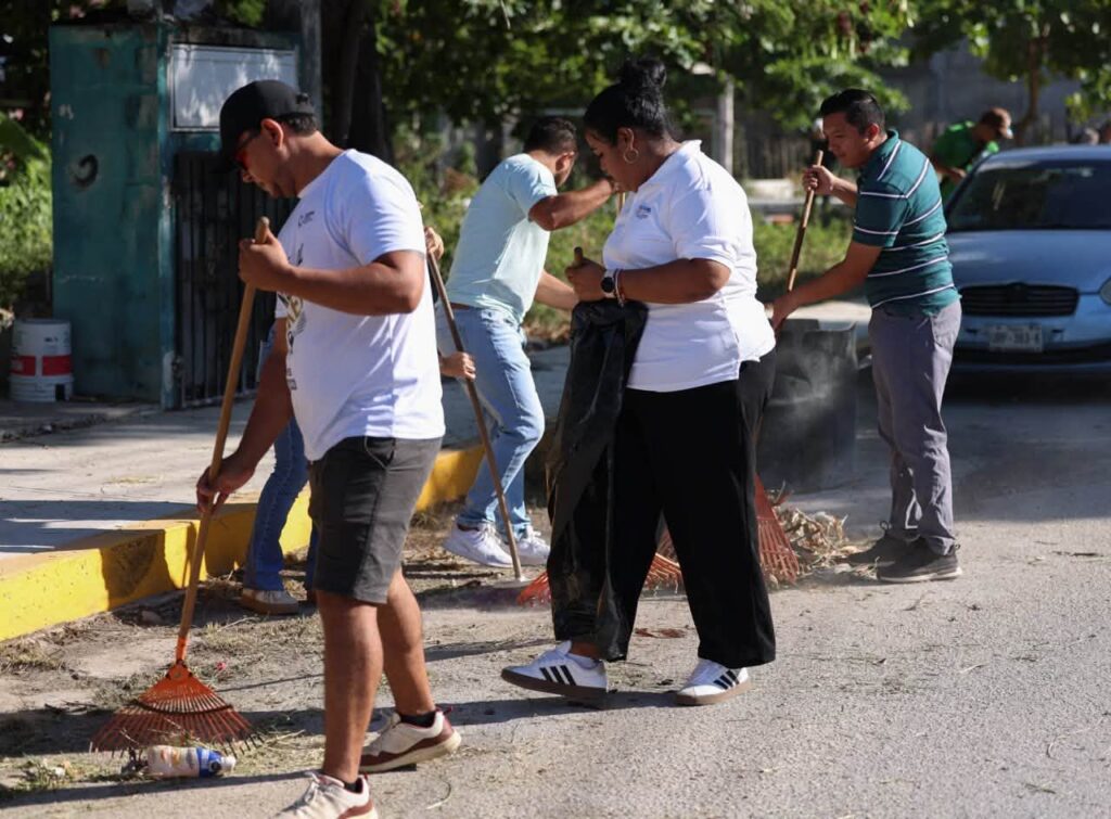 Puerto Morelos residents and workers sweeping a street during a community cleanup.