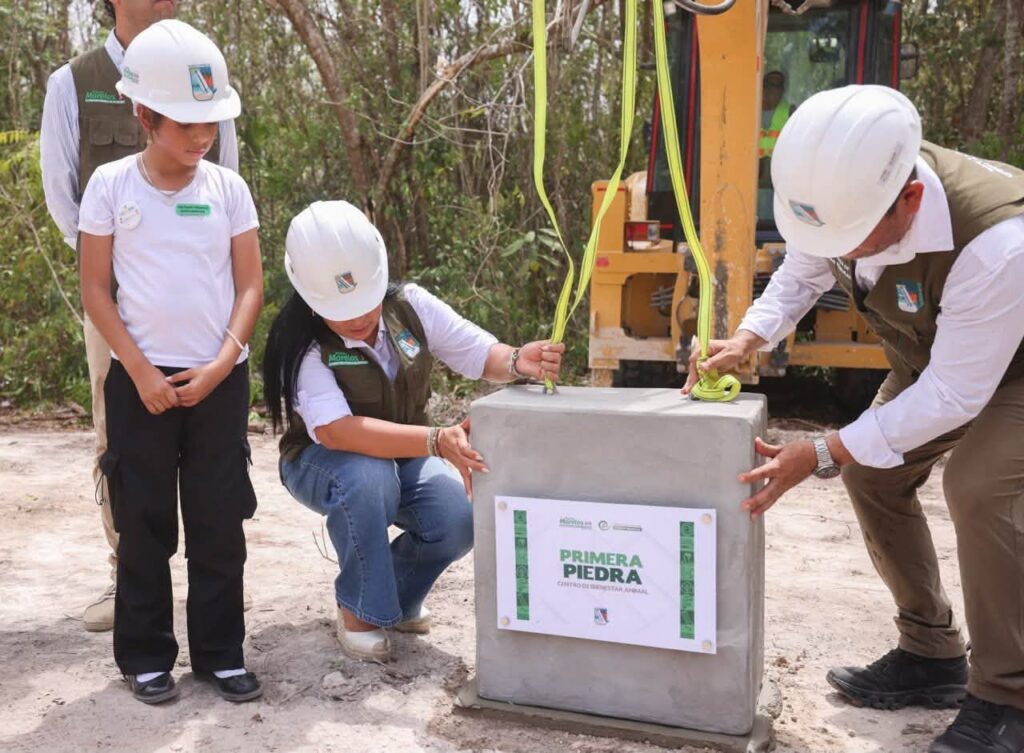 Children and a municipal official place the first stone for the Puerto Morelos Animal Welfare Center.