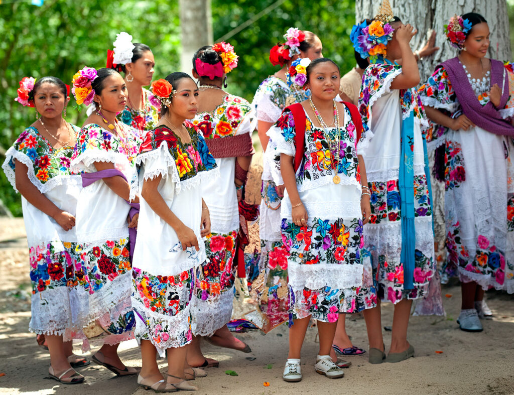 Women wearing colorful embroidered dresses and floral hair decorations