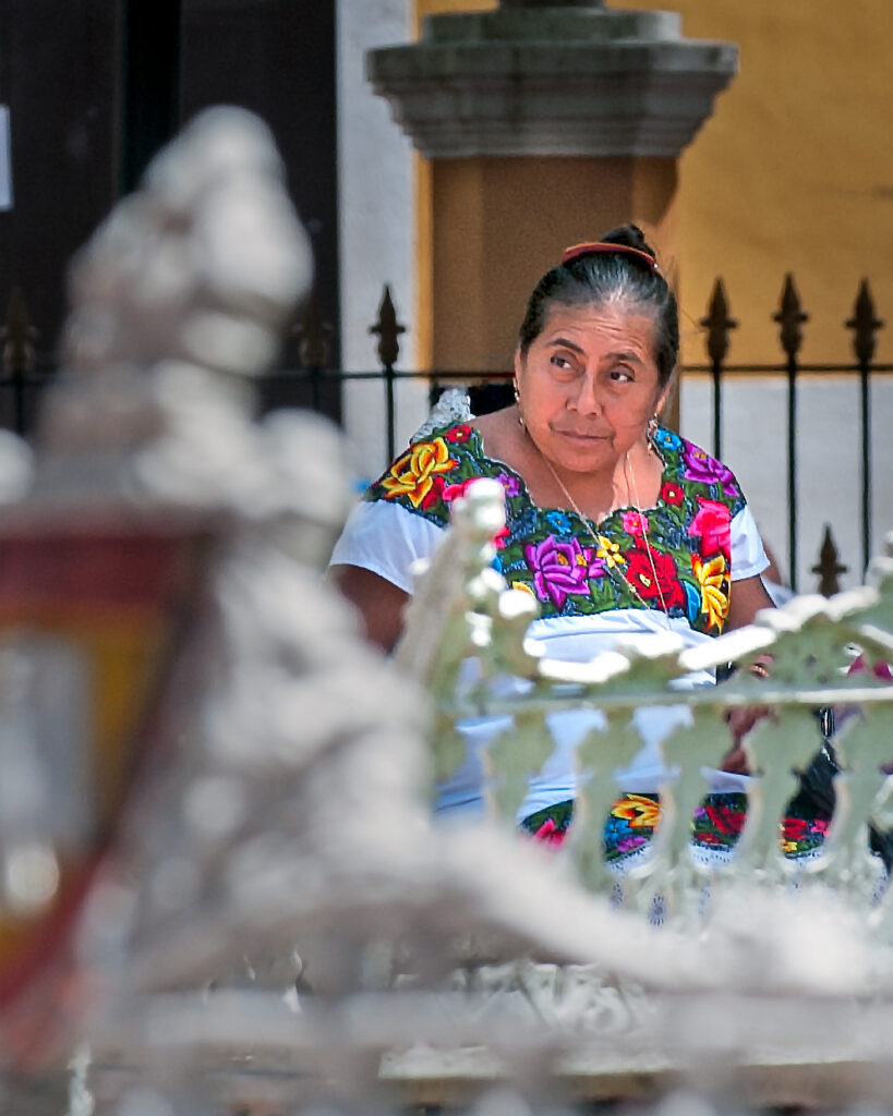 Woman wearing a colorful floral-embroidered huipil