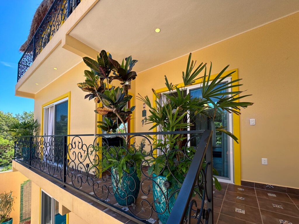 Private upper balcony with iron railings and tropical plants at Casa Catalina #2