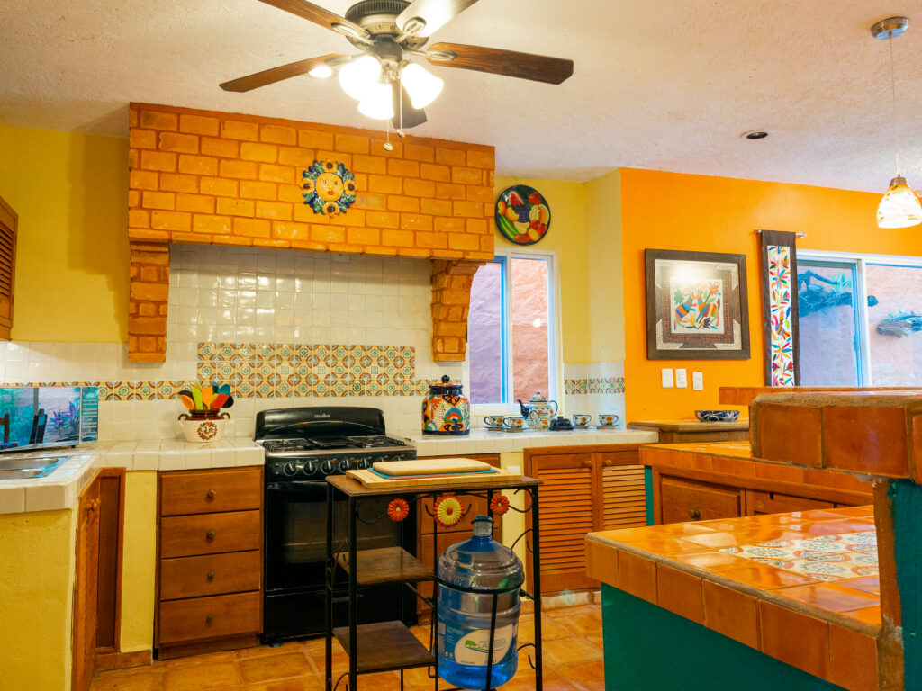 Stove beneath a brick-patterned hood beside wooden cabinets and tiled counters.