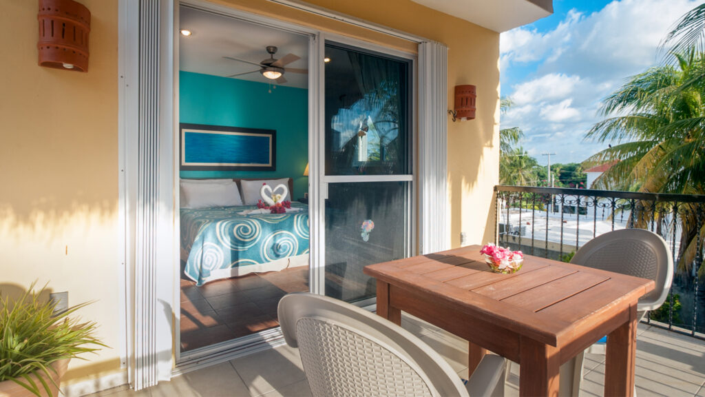 Wooden table and chairs on the terrace outside the bedroom sliding doors.