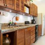 Full kitchen with wooden cabinets and granite counters in Abbey del Sol Apartment #8