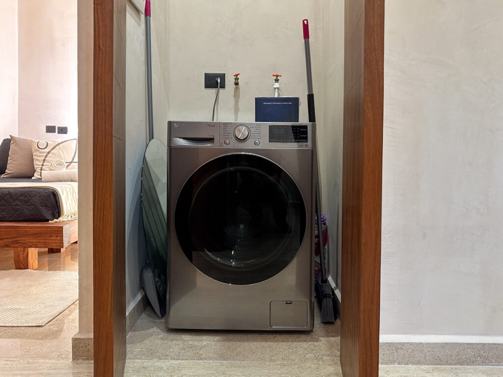 Front-loading washing machine with an ironing board in a recessed laundry space.