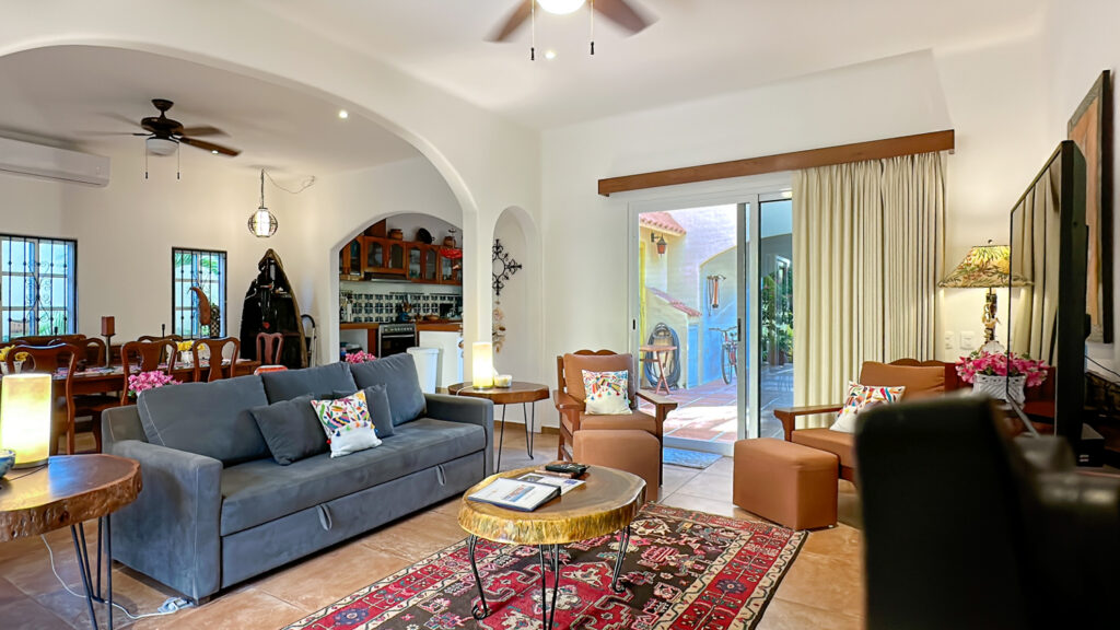 Blue sofa with patterned cushions beside a round table and sliding doors to the patio.