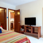 King bedroom with television and full-length mirror in Abbey del Sol Apartment #8