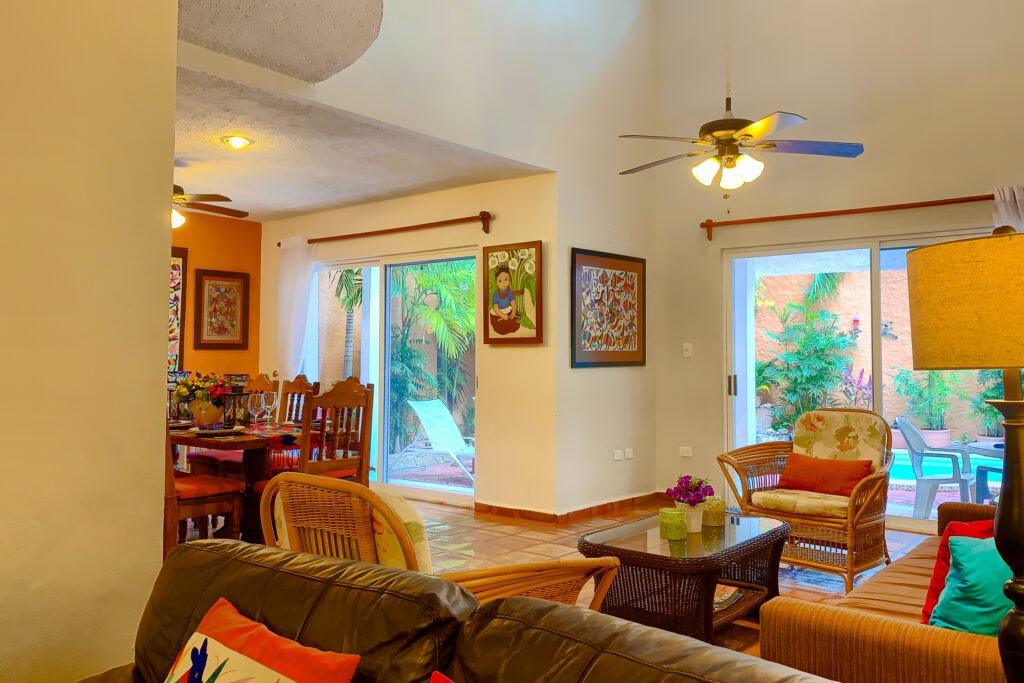 Seating area with wicker furniture beside the dining room and sliding doors to the garden.