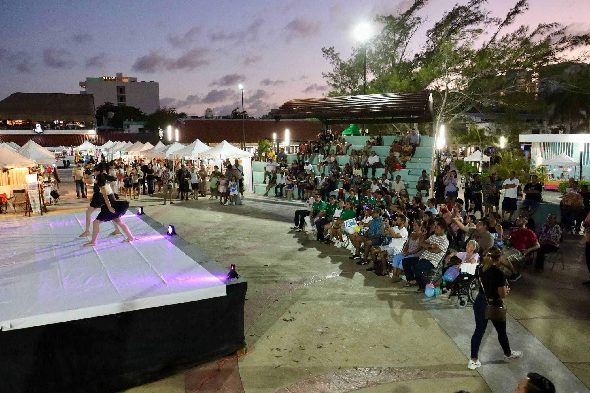 Families and visitors watch an evening performance in the Puerto Morelos park