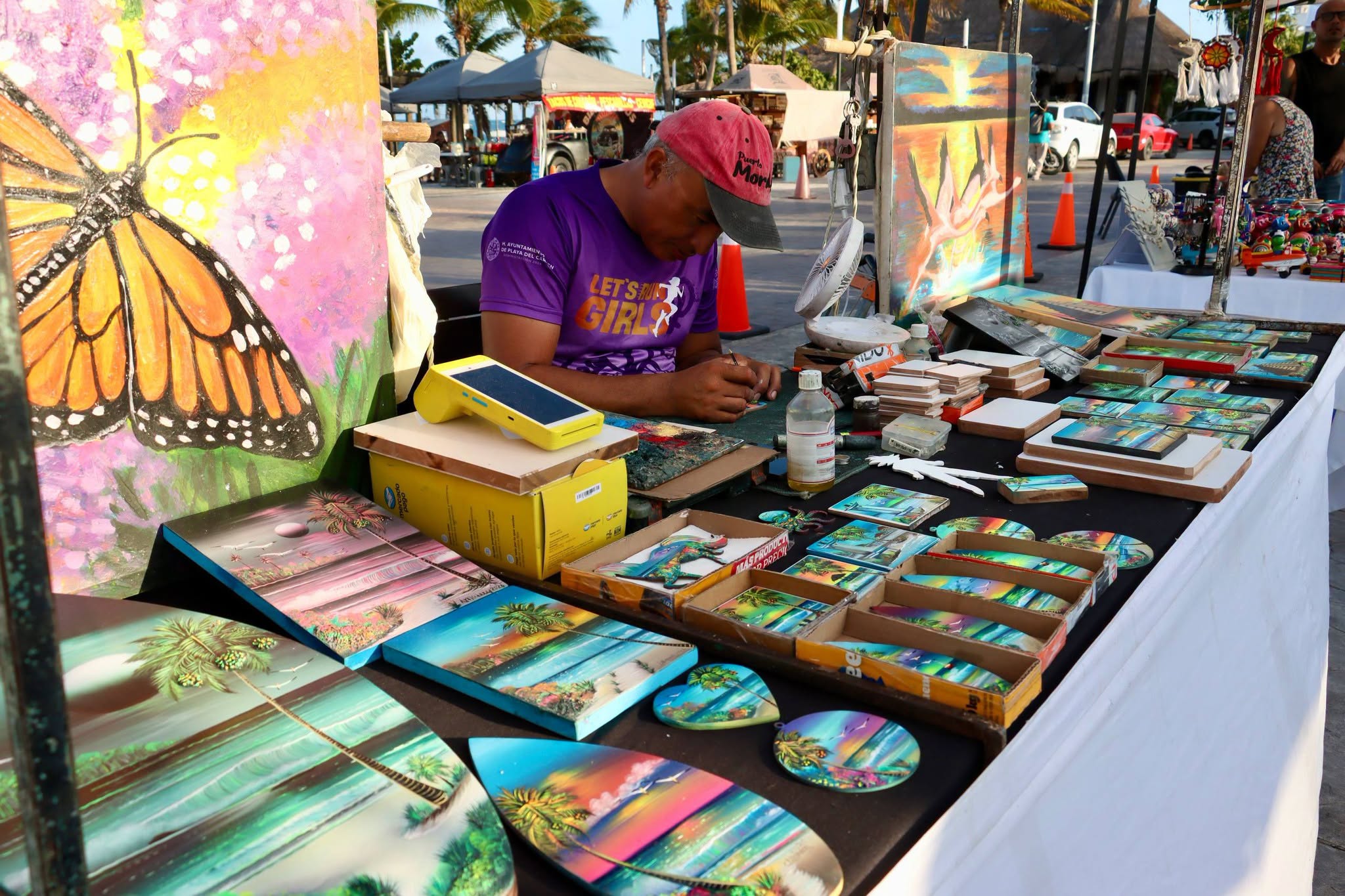 Local artist works among colorful paintings and handmade pieces
