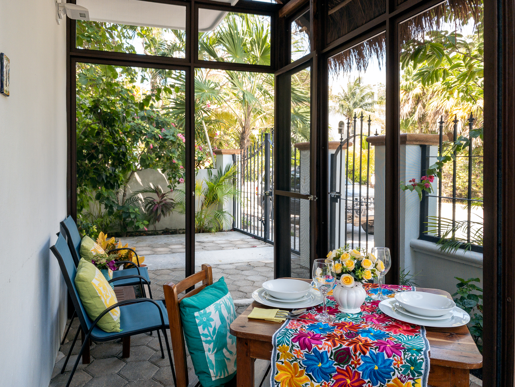 Screened patio with a table set for two and garden views.