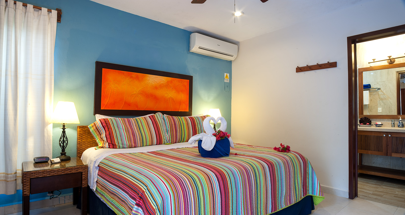 King bedroom with colorful striped bedding in Abbey del Sol Apartment #8